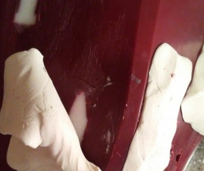 Mineral clay being pulled back after resin dried on the inside of the hull.