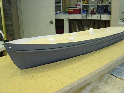All rub rails now completed and I have added the scupper openings and anchor hawses. Hull has been sanded and primed. All deck hatches installed.