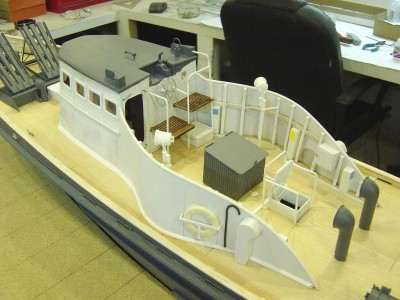 DSC03905.JPG (188.53 KiB) Viewed 7207 times View here from portside. Note the seachlight / signal lights. These are a purchased part while the mount is scratchbuilt from styrene. Ships wheel is cast metal. Grating on flying bridge is laser cut basswood from Bluejacket. All railings here are fabricated styrene rod. Large grey box is life preserver stowage, scratcbuilt from leftover decking material and styrene. Large cowl vents are from a Haynes PT boat, in resin.