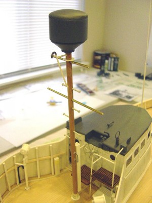 The mainmast assembly. This was scratchbuilt using hardwood dowel for the main shaft, brass tubing for the yardarms. The ladder rungs are small paneling nails. Square tube at lower end of mast is a cable protector. Cable runs from radar dome, down the mast, thru the protector and then runds on deck into pilothouse. Cable yet to be added. Radar dome is three separate pieces. The bottom is a resin casting, mid section is butyrate tubing, while the "dome" is shaped balsa.