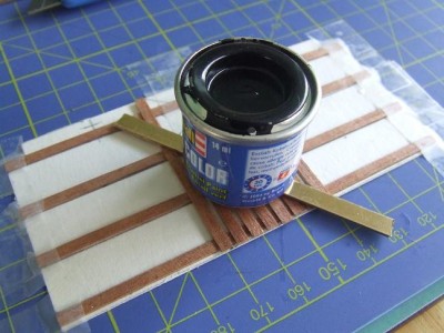 Weighted with a small tin of paint while glue sets