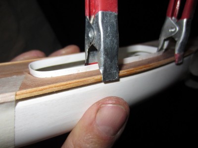 The thin rubbing strake was held in place till the glue had set then sanded to the correct shape.