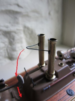 The iron bracket between the two funnels. The red arrow indicates that it would have sat on the deck when the funnels were folded.